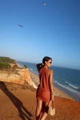 Vestido corto de punto con hilo brillante, escote drapeado, sin mangas y lazo decorativo para atar en la cintura.