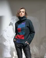 Sweater de lana merino afieltrada color verde oscuro con cuello alto y diseño de bloques de color en azul, rojo y violeta.