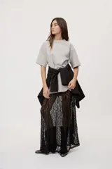 Remera oversized de manga corta y cuello redondo, de color negro con efecto acid wash y aplicación de strass en la parte superior.