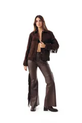 Pantalón semi oxford de cuero ovino color chocolate, con corte ajustado en la parte superior y botamanga acampanada, destacando flecos largos en los laterales.