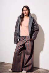 Campera acolchada gris oscuro con efecto lavado, cuello mao y cierre frontal. Presenta un patrón de costura ondulado.