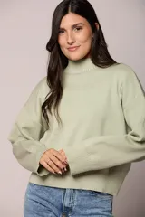Buzo tejido de punto en color verde menta, con cuello alto, mangas largas con puños acanalados y corte holgado.