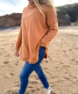 Polerón blanco de morley con cuello alto y volados en ruedo y puños.