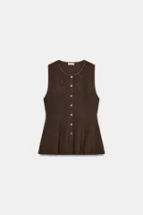 Top de punto marrón oscuro, sin mangas, con cuello redondo y cierre frontal de botones blancos. Presenta un corte ajustado en el torso que se ensancha en un bajo tipo peplum.