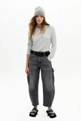 Pantalón de denim con corte barrel relajado y tiro medio, confeccionado en algodón con spandex. Presenta un estampado floral integral sobre fondo negro.