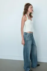 Jeans de tiro medio con diseño baggy barrel, cinco bolsillos y costuras laterales curvadas. Presenta cierre frontal con cremallera y botón metálico.