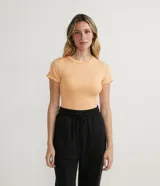 Remera básica de manga corta color naranja claro, confeccionada en tejido ribana, con volados en el cuello y las mangas.