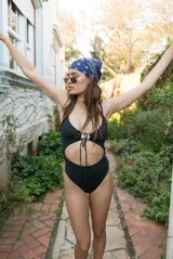 Traje de baño entero negro con breteles finos y escote con abertura ajustable en el centro.