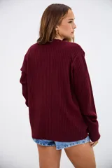 Sweater de tejido de punto acanalado en color bordó, con cuello redondo y mangas largas. Presenta un corte holgado y cómodo.