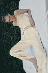 Pantalón de tiro alto confeccionado en tejido satinado, con cintura elástica y bolsillos laterales. Presenta un diseño de corte recto con bajo acabado en aplicación de encaje a tono.