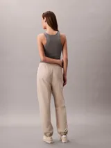 Pantalón de felpa de Calvin Klein de corte relajado, color beige, con cintura elástica ajustable con cordón, bolsillos laterales y puños elásticos en los tobillos.