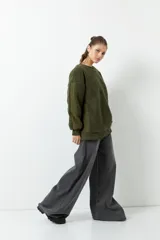 Buzo negro de tela tipo teddy, de manga larga y cuello redondo. Presenta recortes de nylon en mangas y laterales.