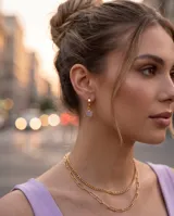 Caravana de acero dorado con diseño de elefantito colgante adornado con pequeñas circonias.