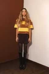 Remera de algodón a rayas horizontales marrones y amarillas, de corte cuadrado y mangas cortas.