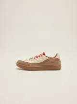 Championes urbanos de cuero en tonos tostado y marrón claro, con detalles en rojo, cordones bicolor, suela de goma y el número 1986 bordado en el talón.