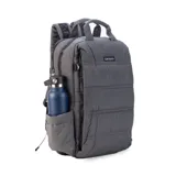 Mochila capitoneada color gris oscuro, con asa superior y correas regulables. Cuenta con doble cierre principal, bolsillo frontal con apertura vertical y bolsillo trasero pequeño. Incluye espacio para laptop de 15 pulgadas y correas ocultables.