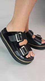 Zuecos de cuero color tostado con plataforma y dos tiras ajustables con hebillas metálicas plateadas.