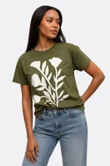 Remera de manga corta color beige, con cuello redondo y diseño de estampado floral grande en el frente.