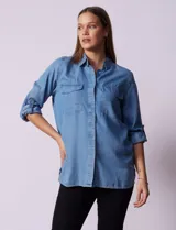 Camisa celeste de tencel con cuello con solapa, abertura central con botones ocultos, bolsillos delanteros y mangas largas regulables con presilla y botón.