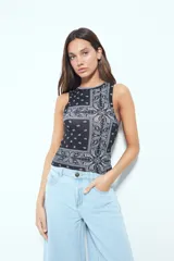 Top crop sin mangas color rojo con estampado tipo bandana en blanco y negro. Tiene cuello cerrado y sisas definidas.