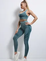 Legging deportivo de tiro alto, confeccionado en tejido sin costuras con diseño texturizado y paneles laterales decorativos en tono más oscuro.