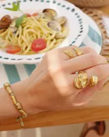 Anillo de diseño abierto con textura escamada que simula la piel de una serpiente, elaborado artesanalmente en metales nobles.