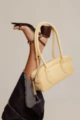 Cartera estilo baguette de cuero color marrón, con doble asa de hombro y cierre de cremallera. Hecha a mano en Uruguay.