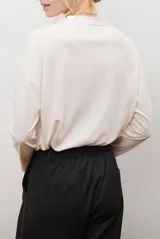 Blusa de color azul oscuro, con cuello mao y escote en V. Presenta mangas largas con puños abotonados y un corte recto y holgado.