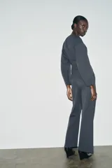 Pantalón de tiro alto con corte ancho y recto, confeccionado en tejido de punto elástico y flexible con cintura elástica.