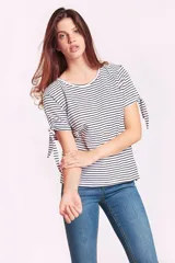 Remera de algodón a rayas horizontales blancas y negras, con cuello redondo y mangas cortas que presentan un detalle de lazo ajustable en los extremos.