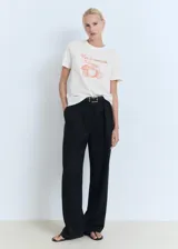 Camiseta blanca de manga corta y cuello redondo, confeccionada en algodón. Presenta un estampado frontal con la frase "Vivi il momento" y un gráfico de naranjas en color rojo.