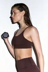 Top deportivo SculptMove color marrón, con escote redondo, breteles finos cruzados en la espalda y bajo elástico. Cuenta con copas forradas con relleno extraíble.
