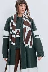 Bufanda de tejido jacquard con diseño de rayas horizontales anchas en color marrón chocolate y rosa. Presenta una textura suave y un estilo envolvente.