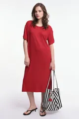 Vestido midi rojo de corte oversized, con cuello a la base, manga corta y tajos laterales. Presenta un parche decorativo en la manga.