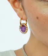 Aros de acero quirúrgico con dije circular de resina rosa y borde de strass dorados.