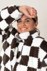 Campera de textura tipo peluche con diseño de cuadros damero en color marrón y blanco. Presenta cuello alto, cierre frontal completo y bolsillos laterales.