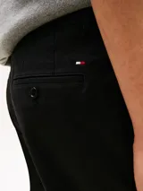 Pantalón chino negro de sarga, confeccionado en mezcla de algodón y elastano, con diseño de pierna recta, bolsillos diagonales en la cintura y bolsillos traseros ribeteados.