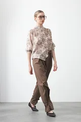 Camisa de manga larga con cuello con volados y botones nacarados. Presenta un estampado romántico de inspiración barroca en tonos azul y beige.