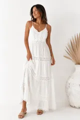 Vestido largo blanco de tirantes finos, con detalles de encaje y inserciones de broderie en el cuerpo y la falda en capas.