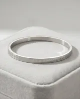 Esclava rígida de acero con diseño grabado de guarda griega en toda su superficie.