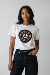 Remera de algodón blanca de manga corta y cuello redondo, con estampado frontal circular que incluye la frase 'ROCK & ROLL' decorada con strass.