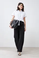 Camisa blanca de corte clásico, con cuello y mangas cortas.