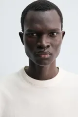 Camiseta de manga larga con corte relajado, confeccionada en tejido compacto de algodón. Presenta cuello redondo acabado en rib y detalle de costura central en la espalda.