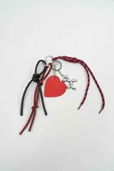 Llavero de diseño versátil con cordones de tela burdeos estampados, tiras de cuero negro y bordó con nudos, dije de corazón rojo y dije metálico de perrito de globo plateado.