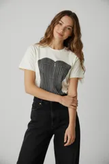Remera de algodón de corte holgado, con cuello redondo a la base y mangas cortas. Presenta un estampado frontal gráfico que simula un corset a rayas.
