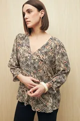Blusa celeste con estampado floral en tonos beige y marrón, escote en V, mangas 3/4 abullonadas y frunce en la cintura.