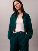 Pantalón deportivo Calvin Klein de pierna ancha y tiro medio, confeccionado en tafetán color verde oscuro. Posee cintura elástica con logo de la marca visible.