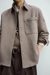 Sobrecamisa de corte regular fit en tejido elástico y transpirable, con cuello solapa, cierre frontal mediante botones a presión y bolsillo de plastrón en el pecho. Presenta mangas largas con puños abotonados y bajo con aberturas laterales.