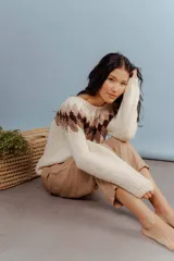 Sweater tejido en lana merino color crudo, con diseño geométrico en tonos marrones en la parte superior.