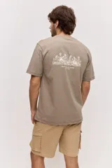 Remera blanca de algodón, de corte holgado y mangas cortas, con pequeño estampado azul en el pecho.